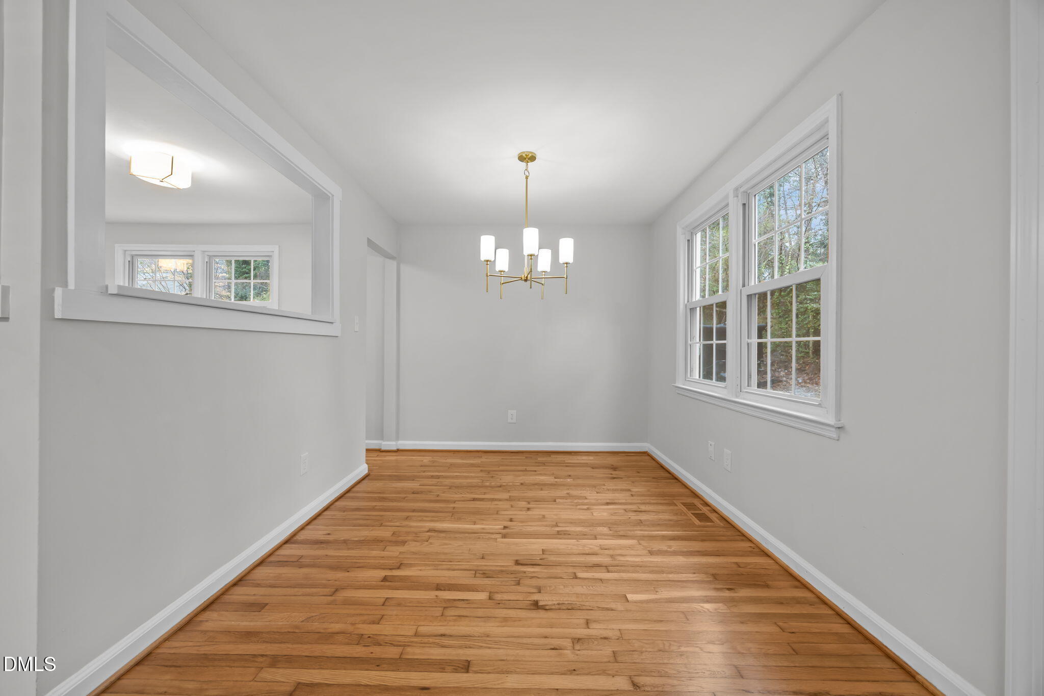 2239 Rumson Road Raleigh, NC 27610 - Photo 15 of 39 a view of an empty room with chandelier and wooden floor