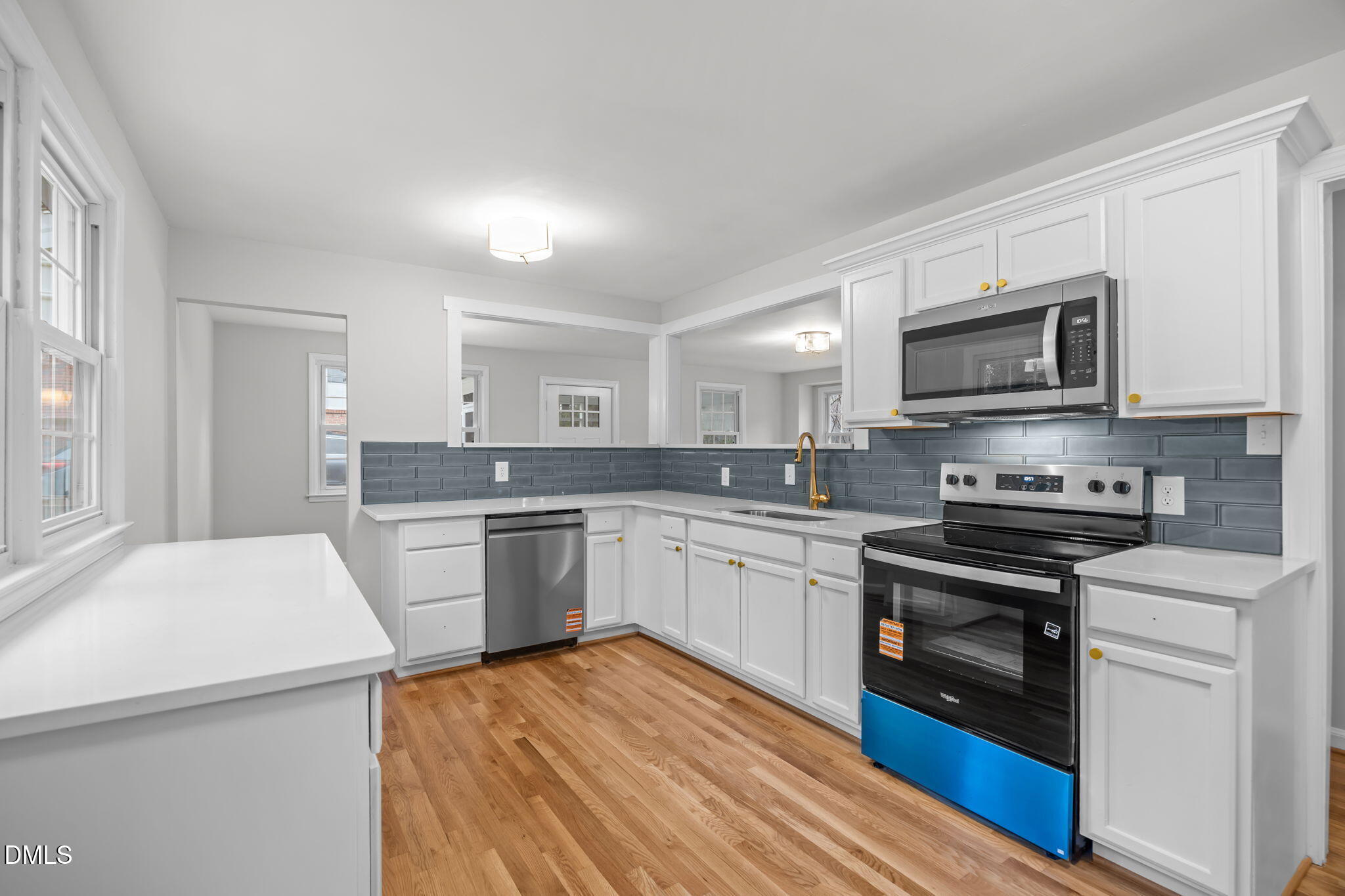 2239 Rumson Road Raleigh, NC 27610 - Photo 20 of 39 a kitchen with stainless steel appliances granite countertop a stove top oven a sink dishwasher and a refrigerator with wooden floor