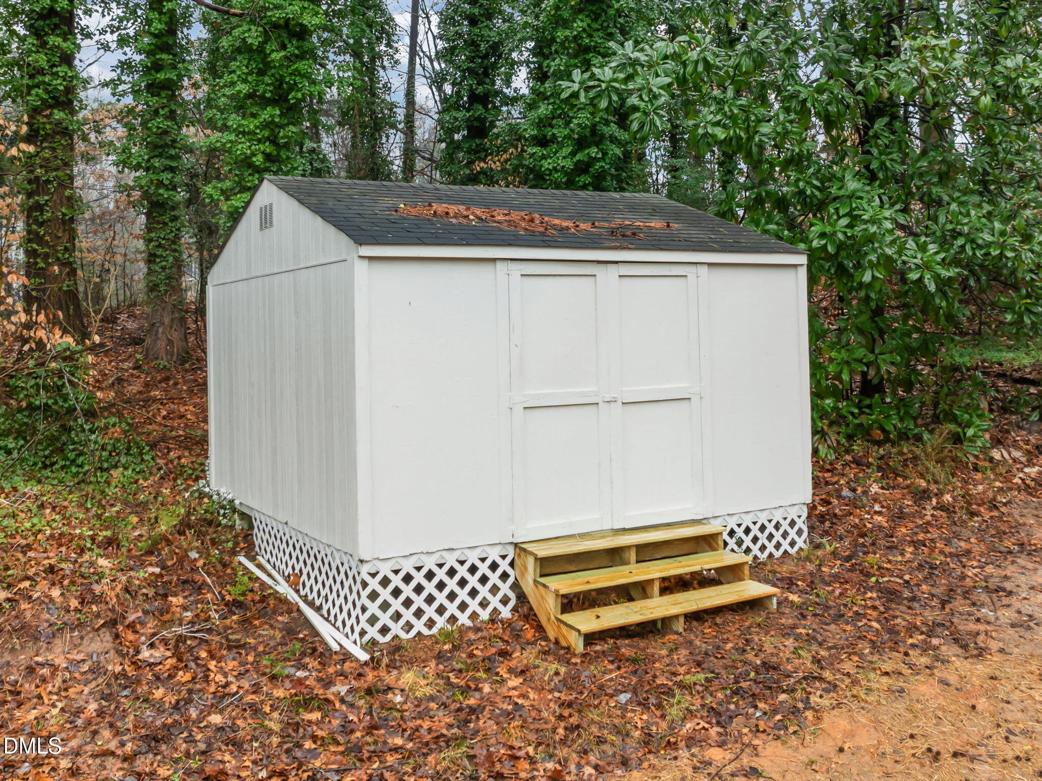 2239 Rumson Road Raleigh, NC 27610 - Photo 7 of 39 a backyard of a house with white walls and a bench