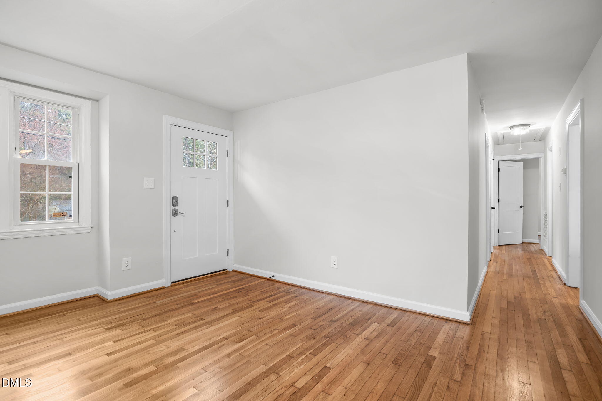 2239 Rumson Road Raleigh, NC 27610 - Photo 8 of 39 an empty room with wooden floor and windows