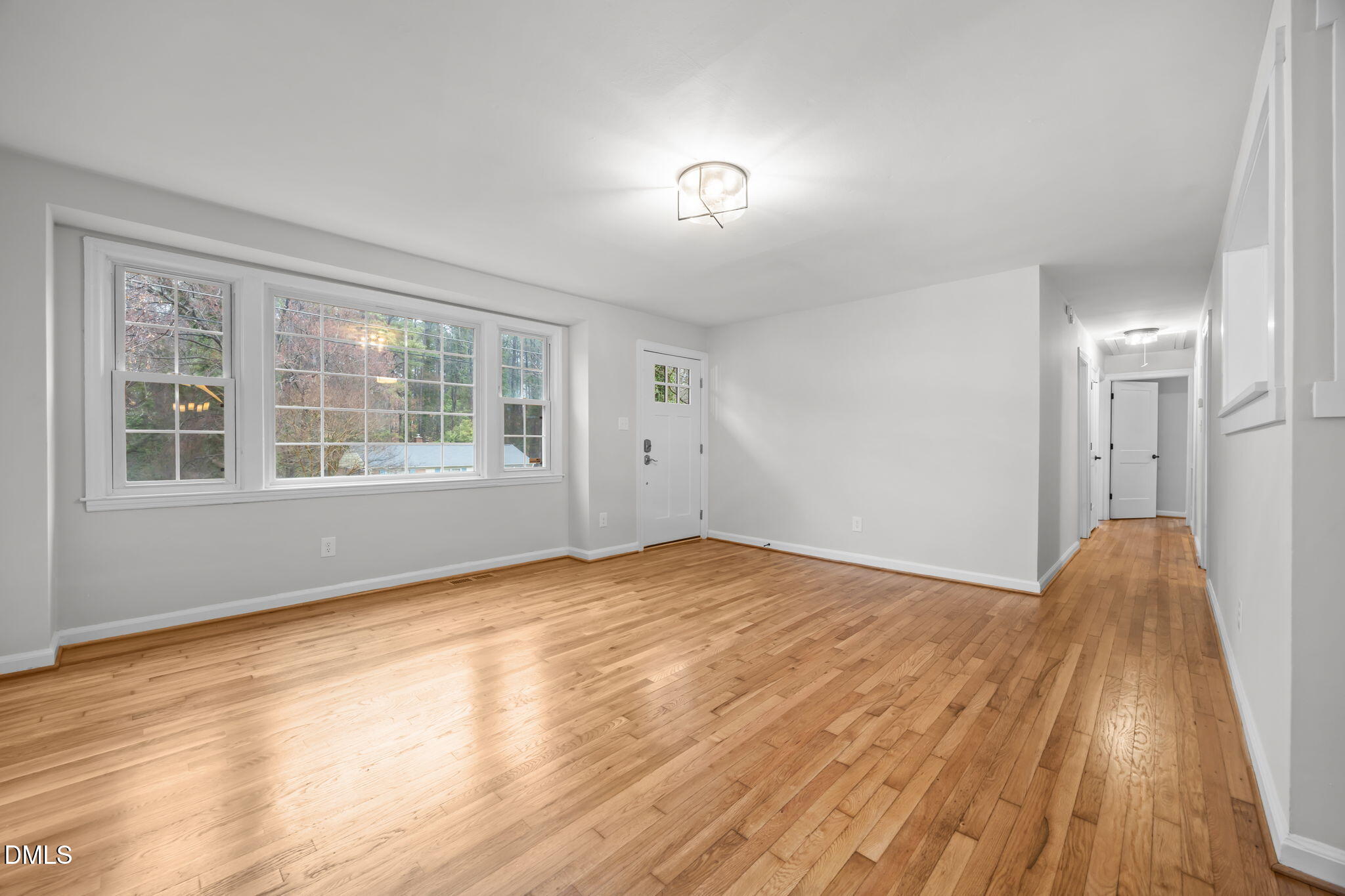 2239 Rumson Road Raleigh, NC 27610 - Photo 9 of 39 a view of an empty room with wooden floor and a window
