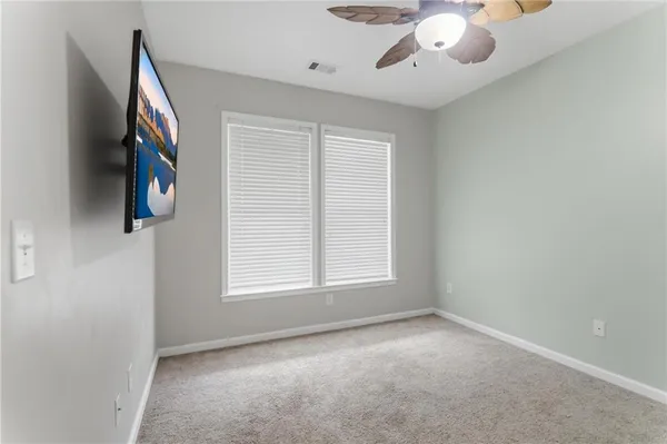 an empty room with windows and fan