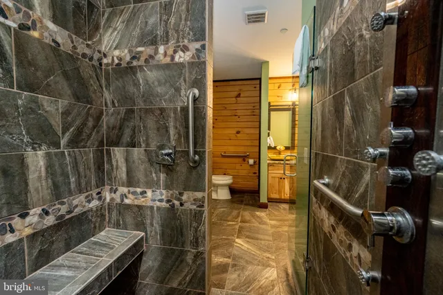 a bathroom with a granite countertop toilet sink and mirror