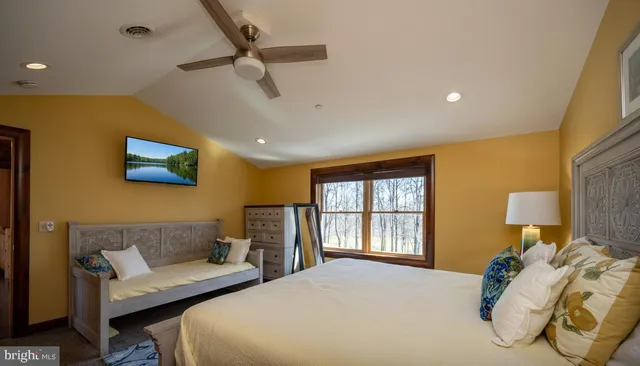 a view of a brick house with large windows and lawn chairs