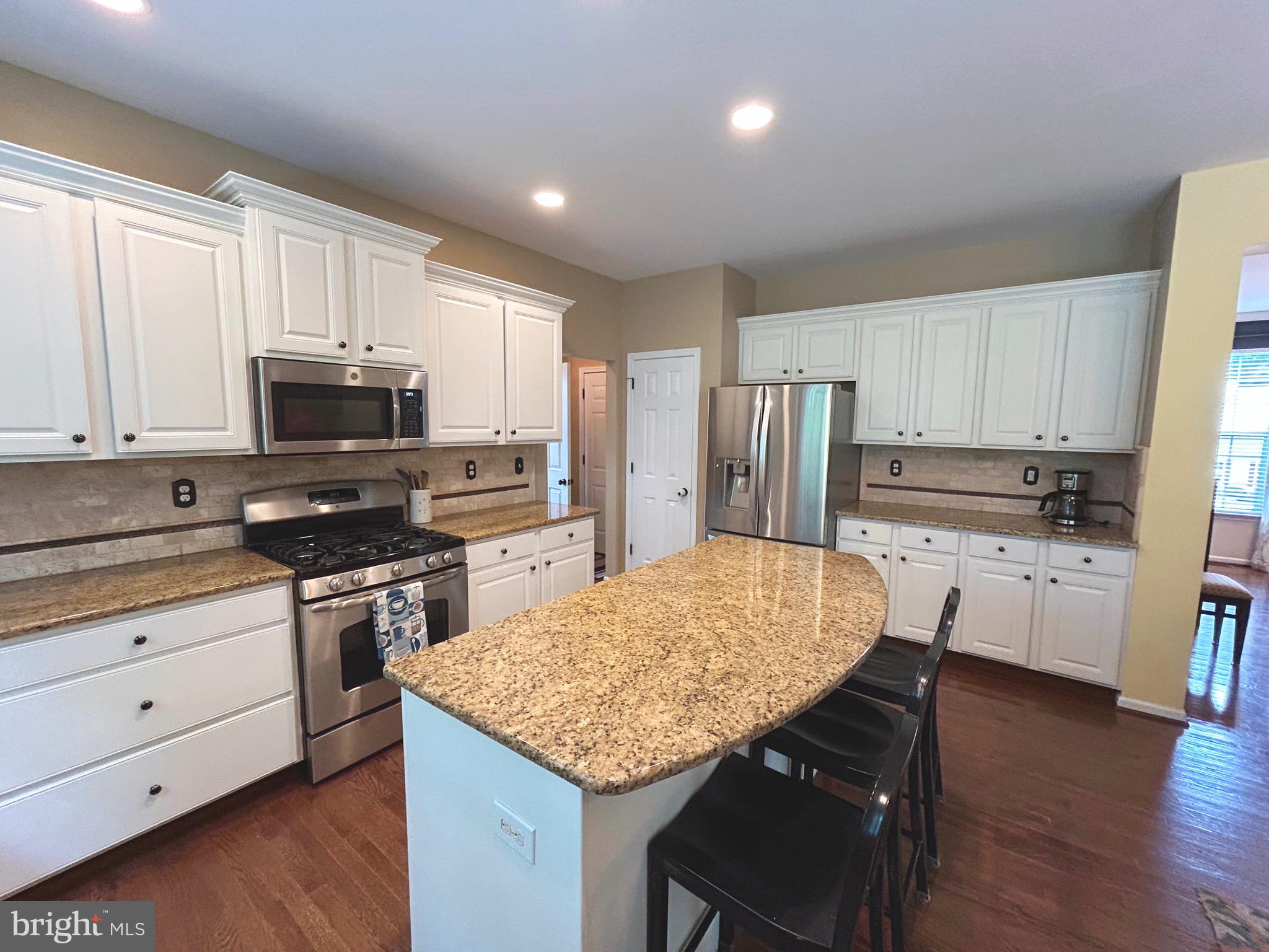 25 Baldwin Circle Glenmoore, PA 19343 - Photo 11 of 33 a kitchen with refrigerator cabinets and wooden floor
