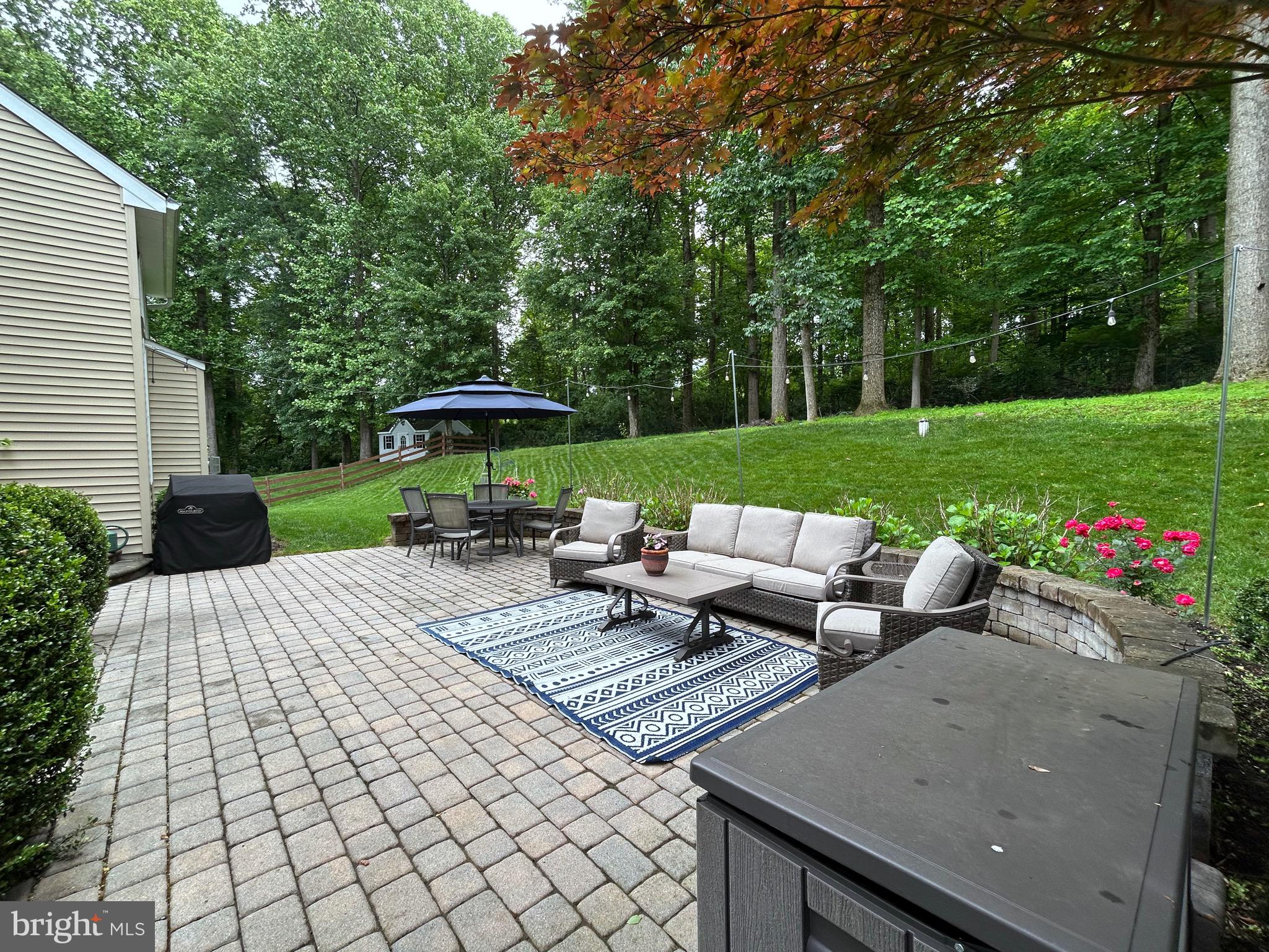 25 Baldwin Circle Glenmoore, PA 19343 - Photo 29 of 33 a view of a patio with couches and table and chairs under an umbrella
