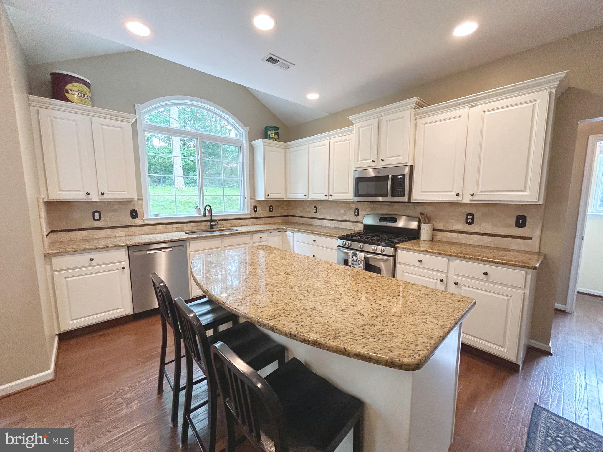25 Baldwin Circle Glenmoore, PA 19343 - Photo 9 of 33 a kitchen with granite countertop a stove a sink a dining table and chairs