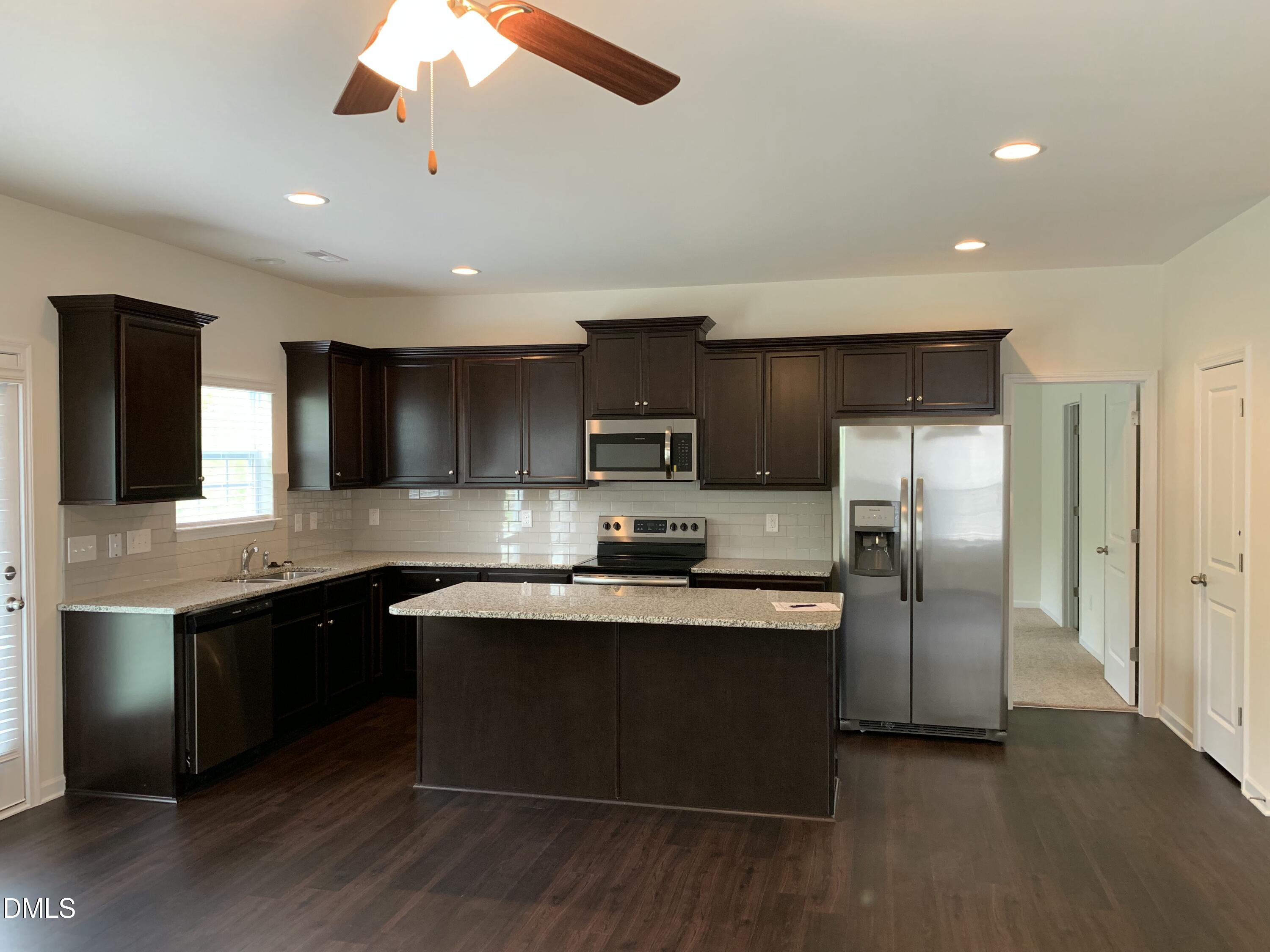 1249 Turkey Trot Road Wendell, NC 27591 - Photo 10 of 42 a large kitchen with stainless steel appliances granite countertop a sink and a refrigerator