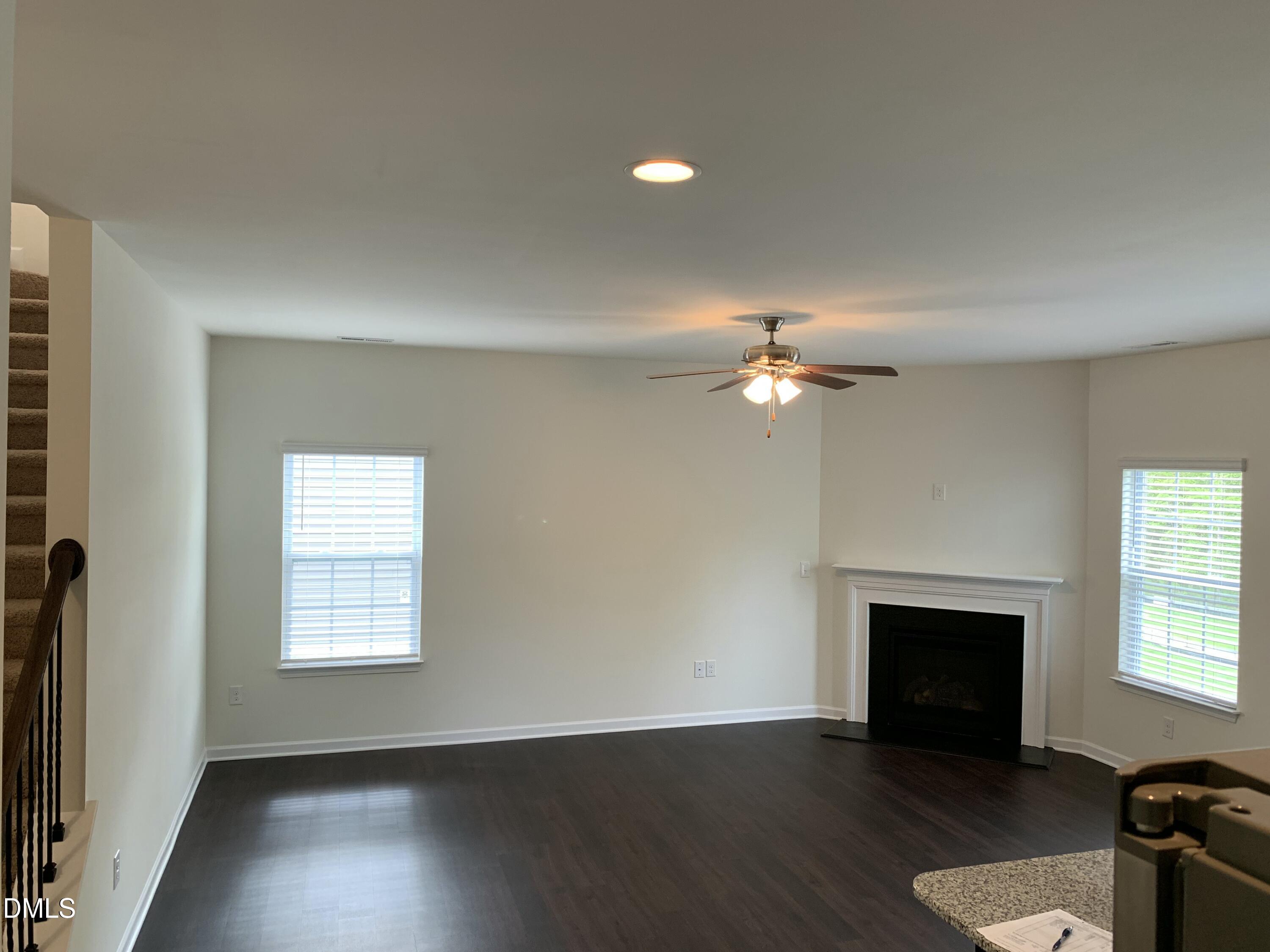 1249 Turkey Trot Road Wendell, NC 27591 - Photo 12 of 42 an empty room with wooden floor a chandelier fan and windows