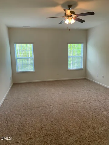 an empty room with a window and a fan