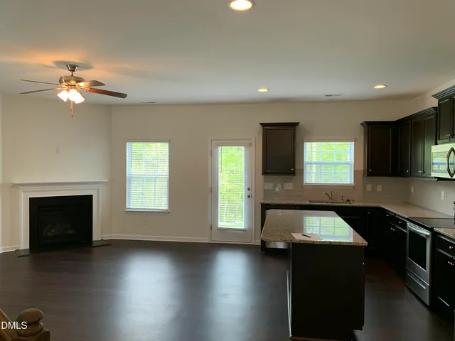 a kitchen with a stove and a wooden floor