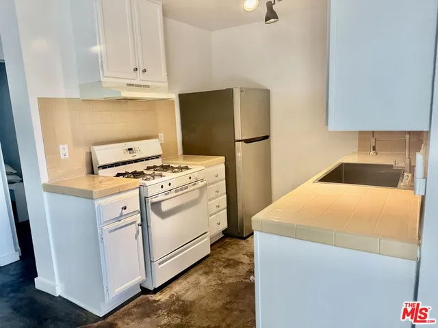a kitchen with appliances a sink and a stove