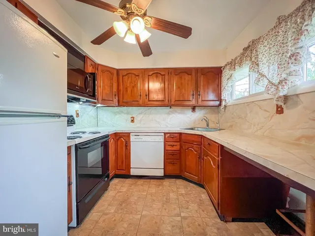 a kitchen with stainless steel appliances granite countertop a sink window and cabinets