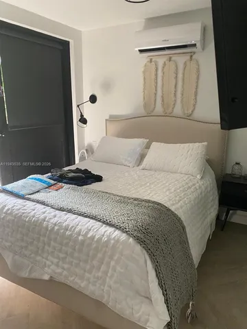 a bedroom with a bed and a flat tv screen on the dresser