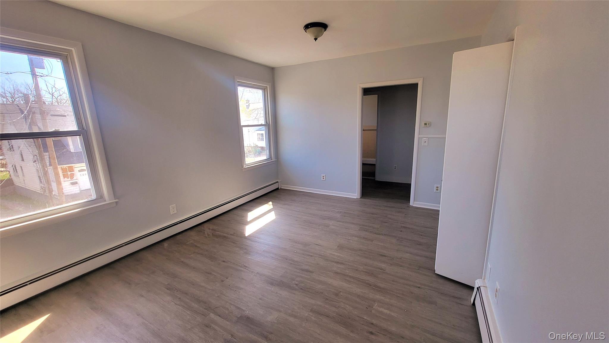 531 West Haight Avenue, Unit H2 Poughkeepsie, NY 12603 - Photo 5 of 8 a view of an empty room with wooden floor and a window
