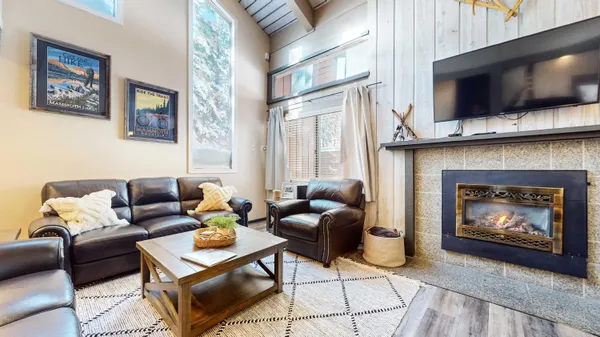 a living room with furniture a flat screen tv and a fireplace