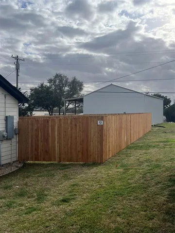 a view of a backyard with wooden fence