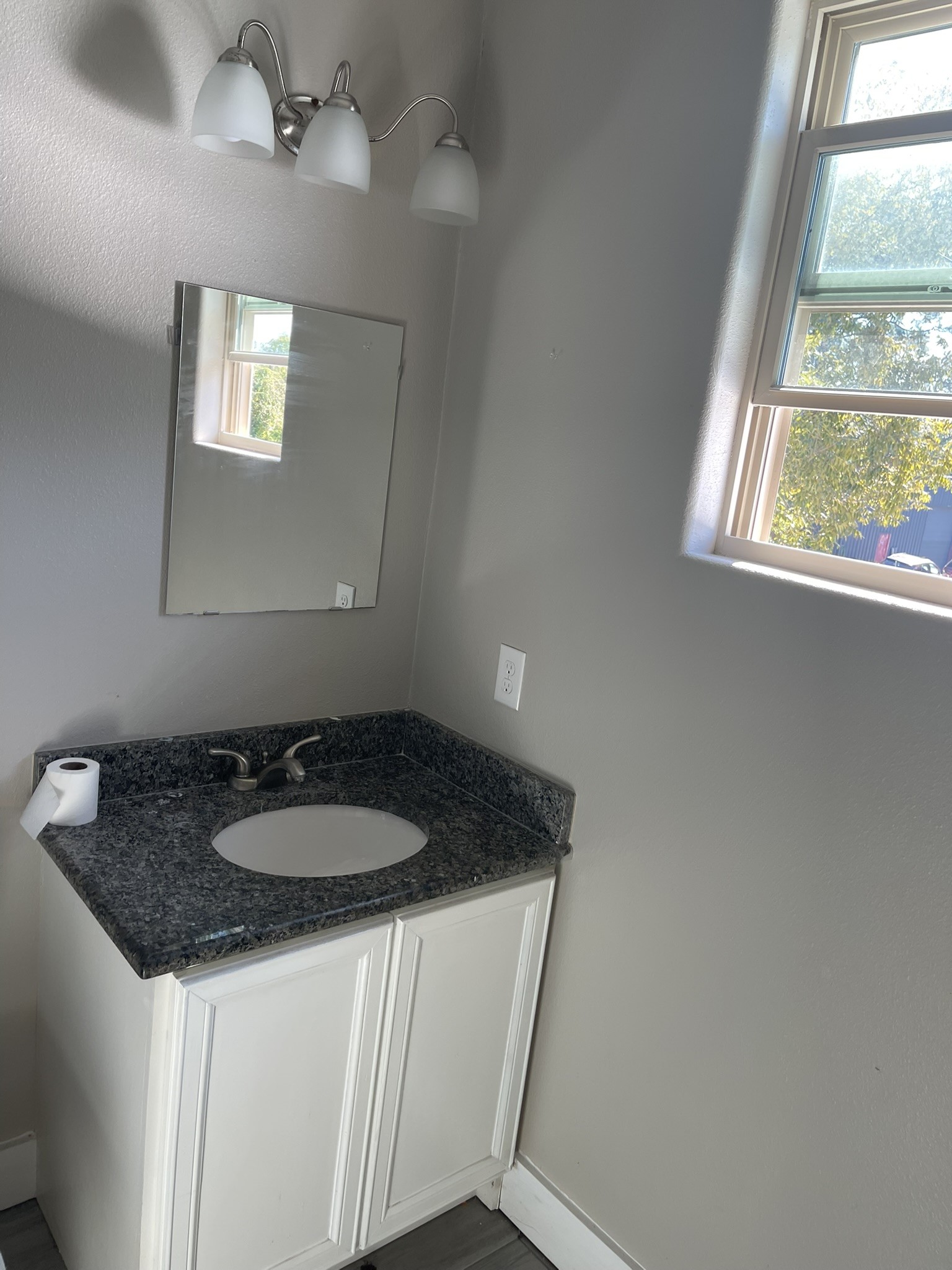 5829 Hartwick Road Houston, TX 77016 - Photo 12 of 47 a bathroom with a granite countertop sink a window and a mirror