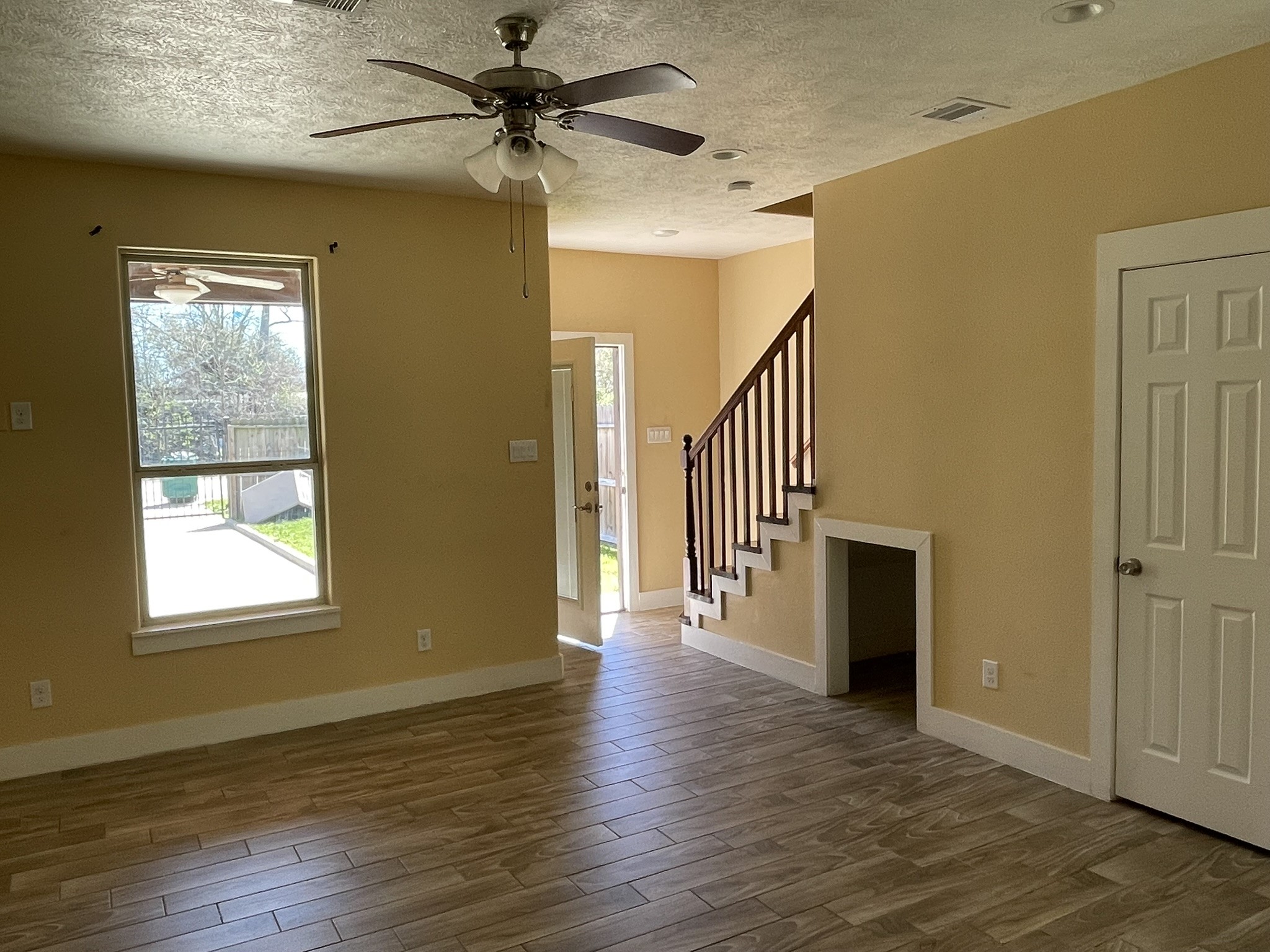 5829 Hartwick Road Houston, TX 77016 - Photo 19 of 47 an empty room with wooden floor fan and windows