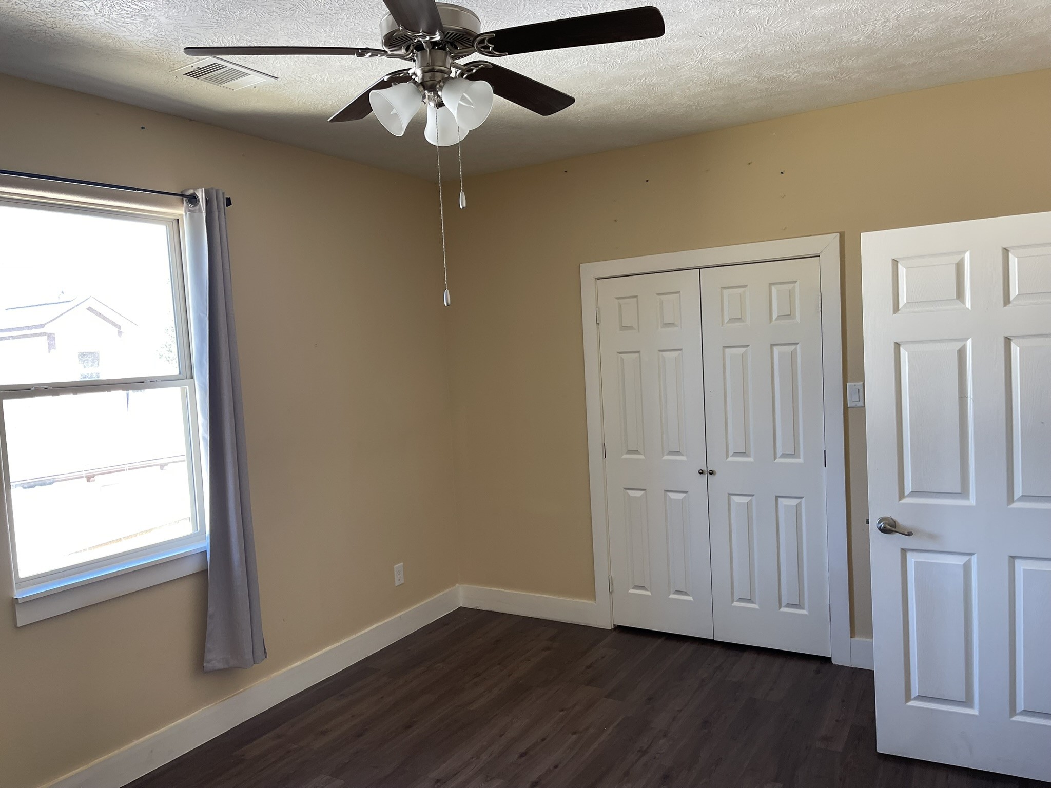 5829 Hartwick Road Houston, TX 77016 - Photo 24 of 47 an empty room with wooden floor fan and windows