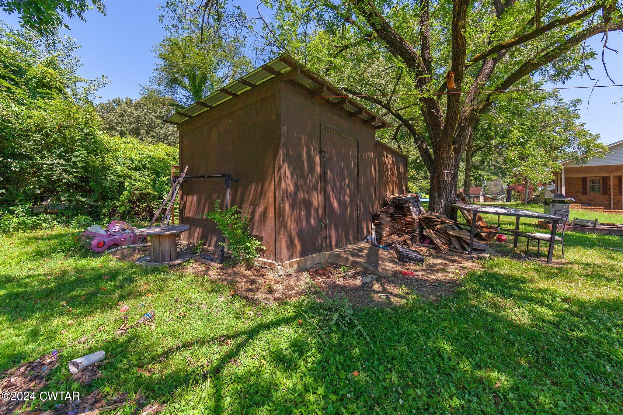 119 Robertson Avenue Camden, TN 38320 - Photo 14 of 28 a view of backyard with table and chairs and potted plants