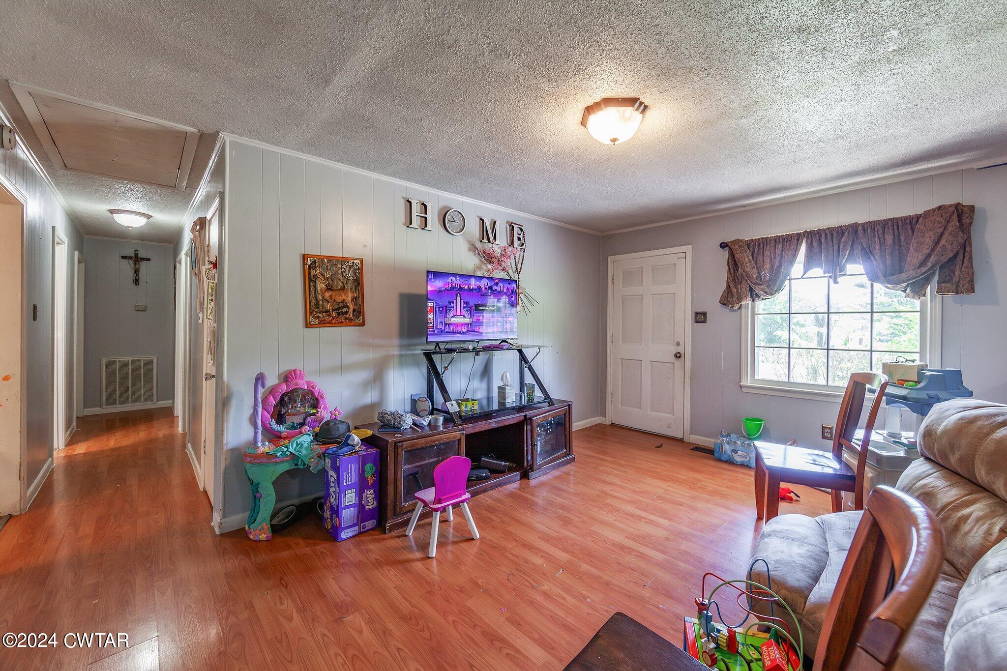 119 Robertson Avenue Camden, TN 38320 - Photo 17 of 28 a view of a livingroom with furniture wooden floor and windows