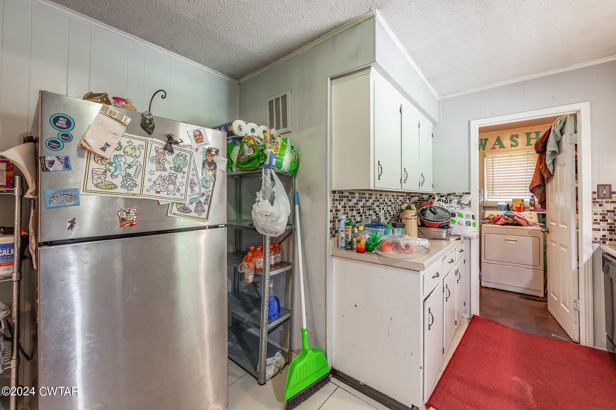 119 Robertson Avenue Camden, TN 38320 - Photo 22 of 28 a view of a kitchen with fridge and workspace
