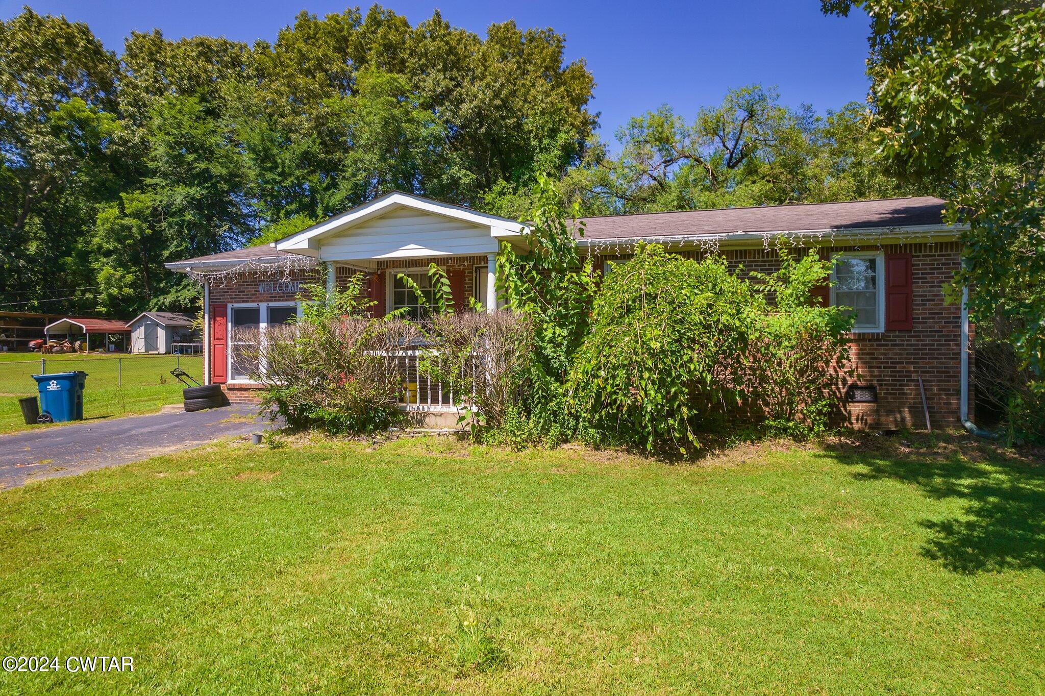 119 Robertson Avenue Camden, TN 38320 - Photo 7 of 28 a view of a house with a yard and sitting area