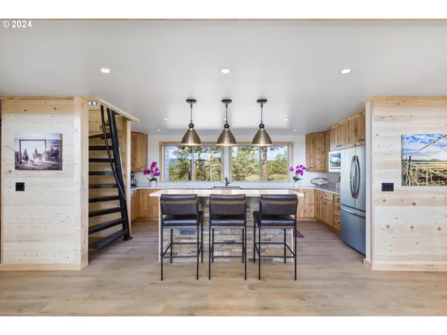 a kitchen with stainless steel appliances kitchen island granite countertop a stove a sink and a microwave