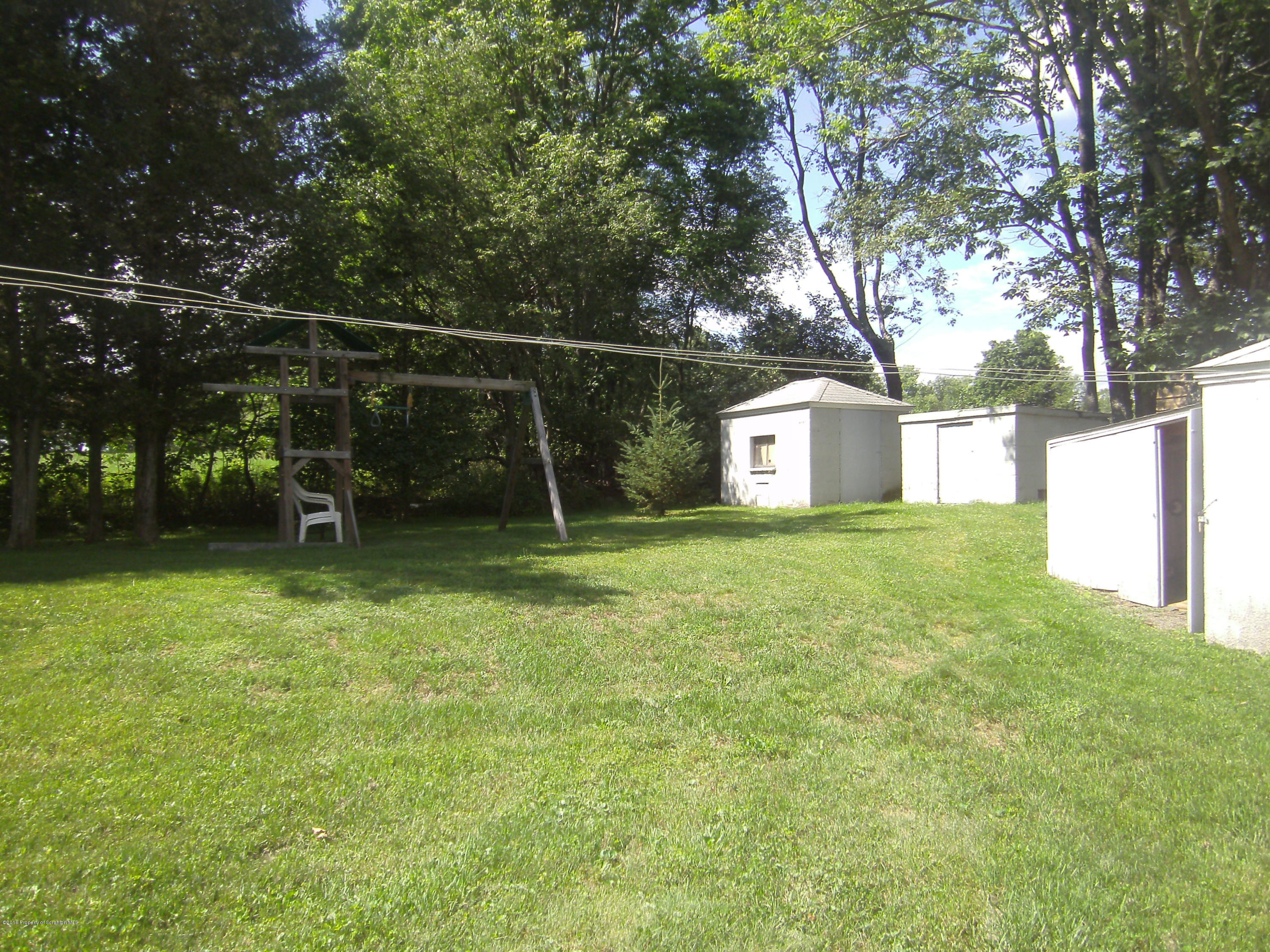 855 Becks Crossing Road Moscow, PA 18444 - Photo 32 of 43 a backyard of a house with childrens swings and slides
