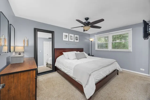 a spacious bedroom with a bed and a dresser next to a window