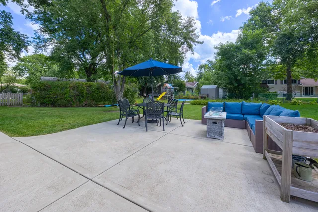 a view of backyard with outdoor seating barbeque oven and trees