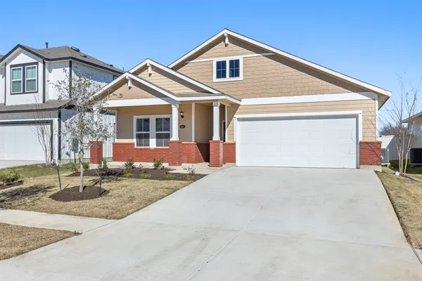 a front view of a house with garage and parking