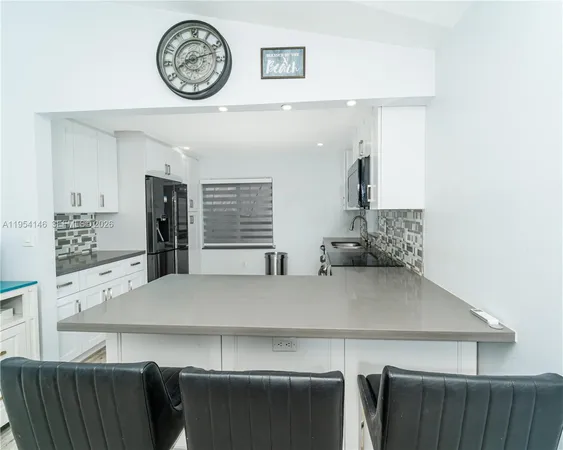 a kitchen with granite countertop a stove sink and cabinets