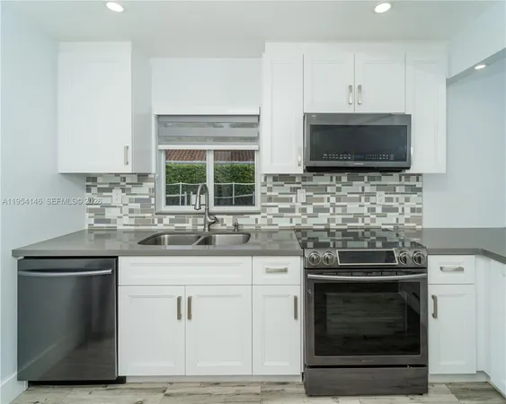 a kitchen with stainless steel appliances granite countertop a refrigerator and a stove