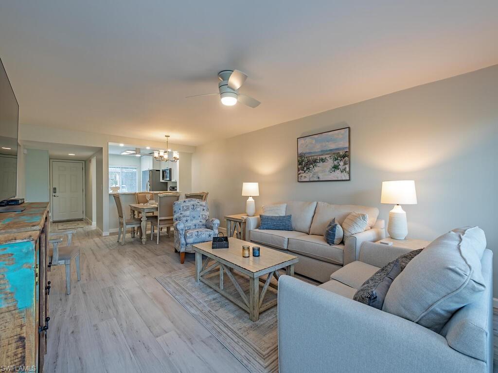 4556 Andover Way, Unit E104 Naples, FL 34112 - Photo 2 of 12 a living room with furniture and wooden floor