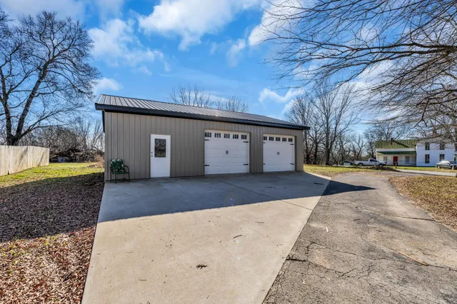 a front view of a house with swimming pool and green space