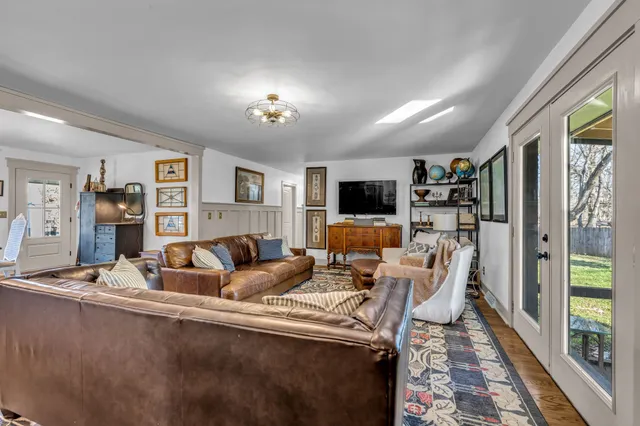 a kitchen with stainless steel appliances a dining table chairs and a refrigerator