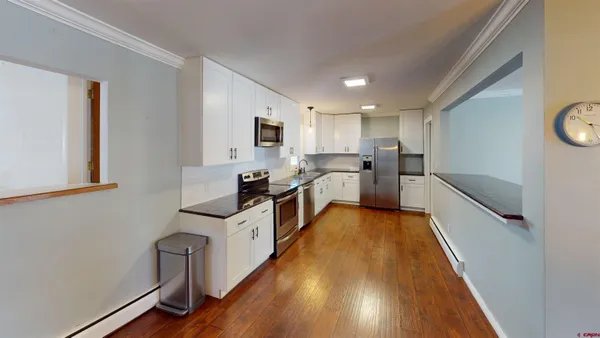 a kitchen with granite countertop a sink a counter top space stainless steel appliances and cabinets