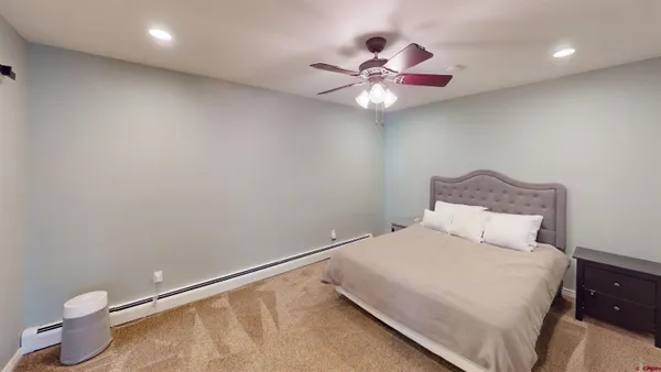 a bedroom with a bed and a painting on the wall