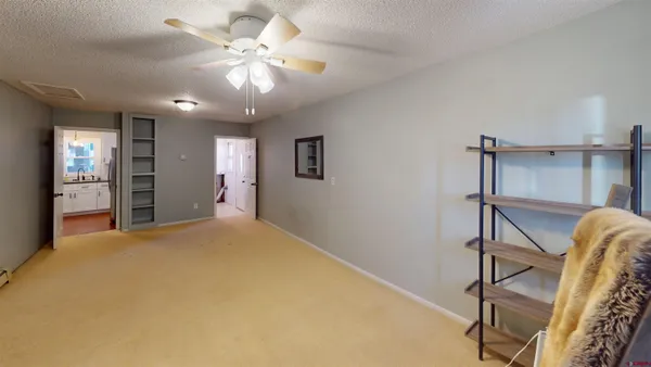 a view of an empty room with a chandelier fan