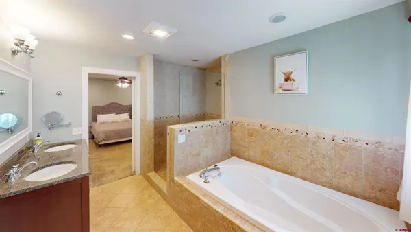 a en suite bathroom with a granite countertop tub and a sink