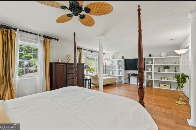 a bedroom with a bed chandelier and view of living room