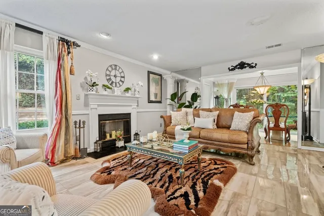 a living room with furniture large window and a fireplace