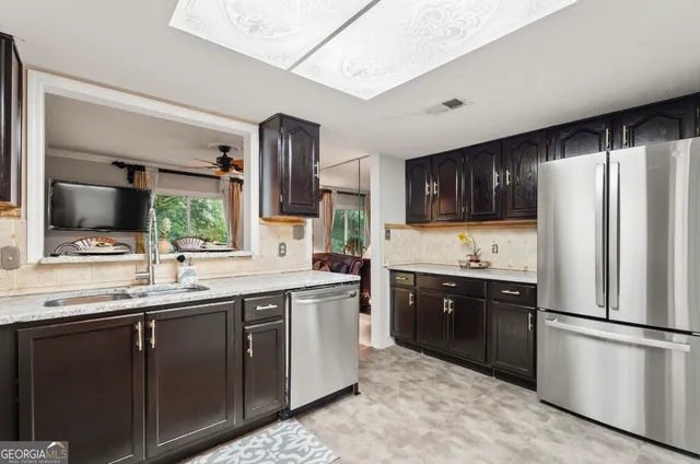 a kitchen with stainless steel appliances granite countertop a refrigerator stove a sink dishwasher and microwave