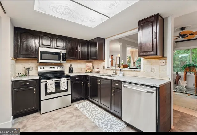 a kitchen with granite countertop wooden cabinets a stove top oven and stainless steel appliances