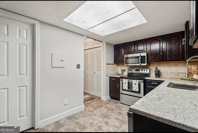 a kitchen with stainless steel appliances granite countertop a refrigerator a stove top oven a sink and dishwasher