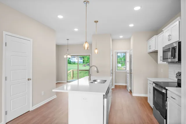 a kitchen with a sink a counter top space stainless steel appliances and a large window