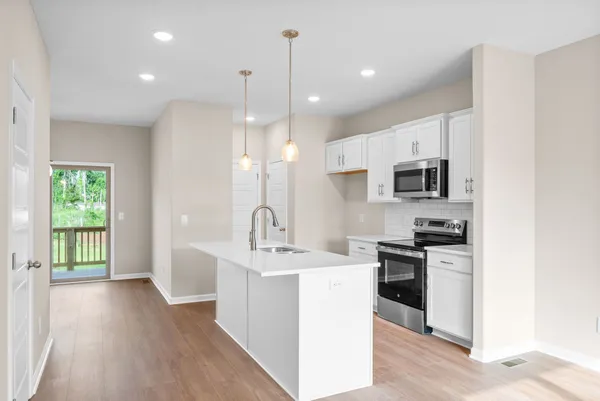 a kitchen with stainless steel appliances kitchen island a sink stove and cabinets