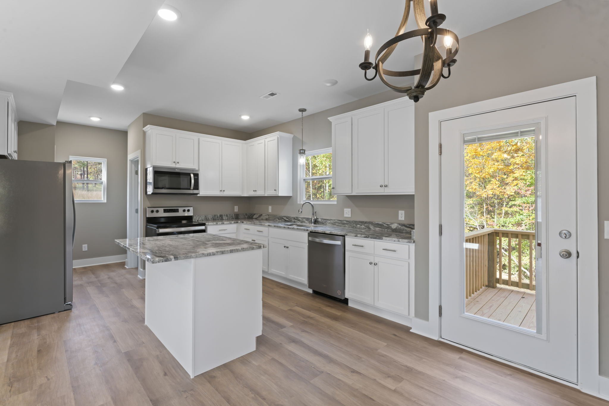 4357 Surji Circle Centerville, TN 37033 - Photo 11 of 25 a kitchen with stainless steel appliances granite countertop a refrigerator a stove oven a sink dishwasher and white cabinets with wooden floor